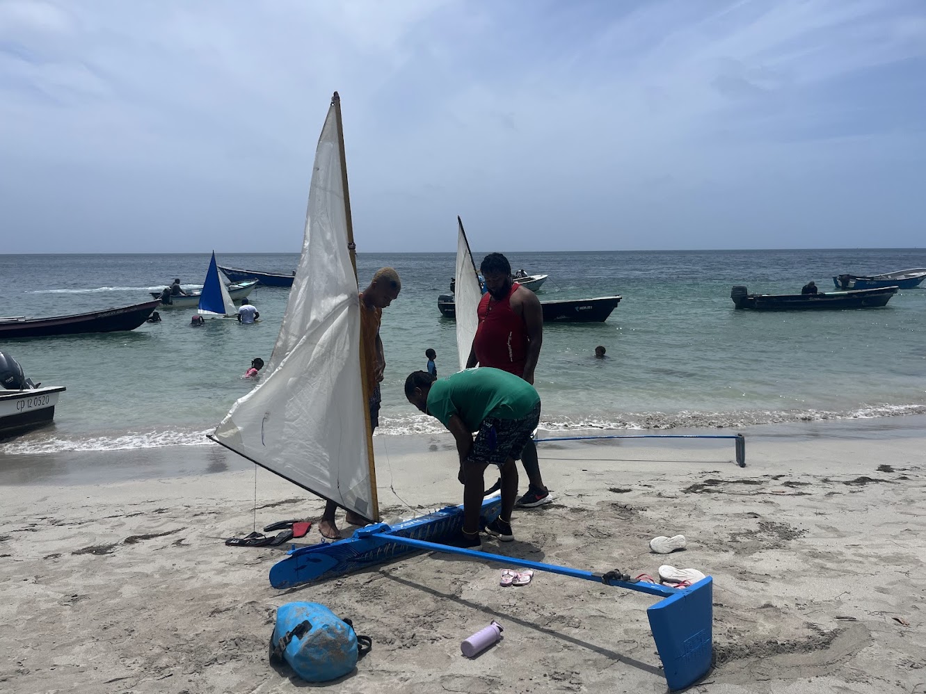 A cultural event we witnessed and photographed of cat boat racing that occurs during the week of the festival, Carnival. Here are a group of men putting together their cat boat before the race begins.  