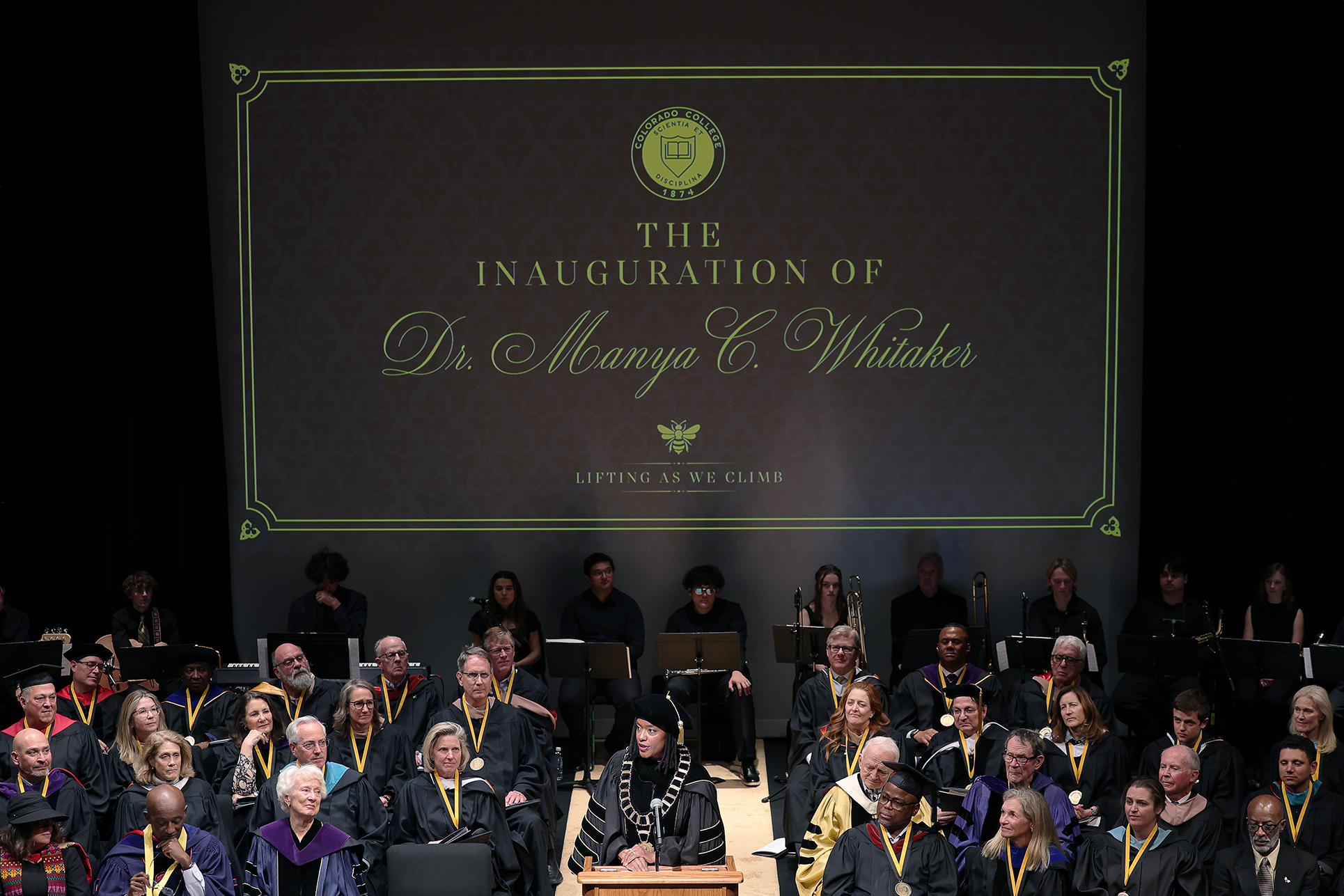 President Manya Whitaker speaks before a crowd of faculty, staff, students, visiting educators, her family, and members of her sorority, as the Board of Trustees and other special guests sit behind her on stage at Richard Celeste Theatre. Photo by Jamie Cotten / Colorado College