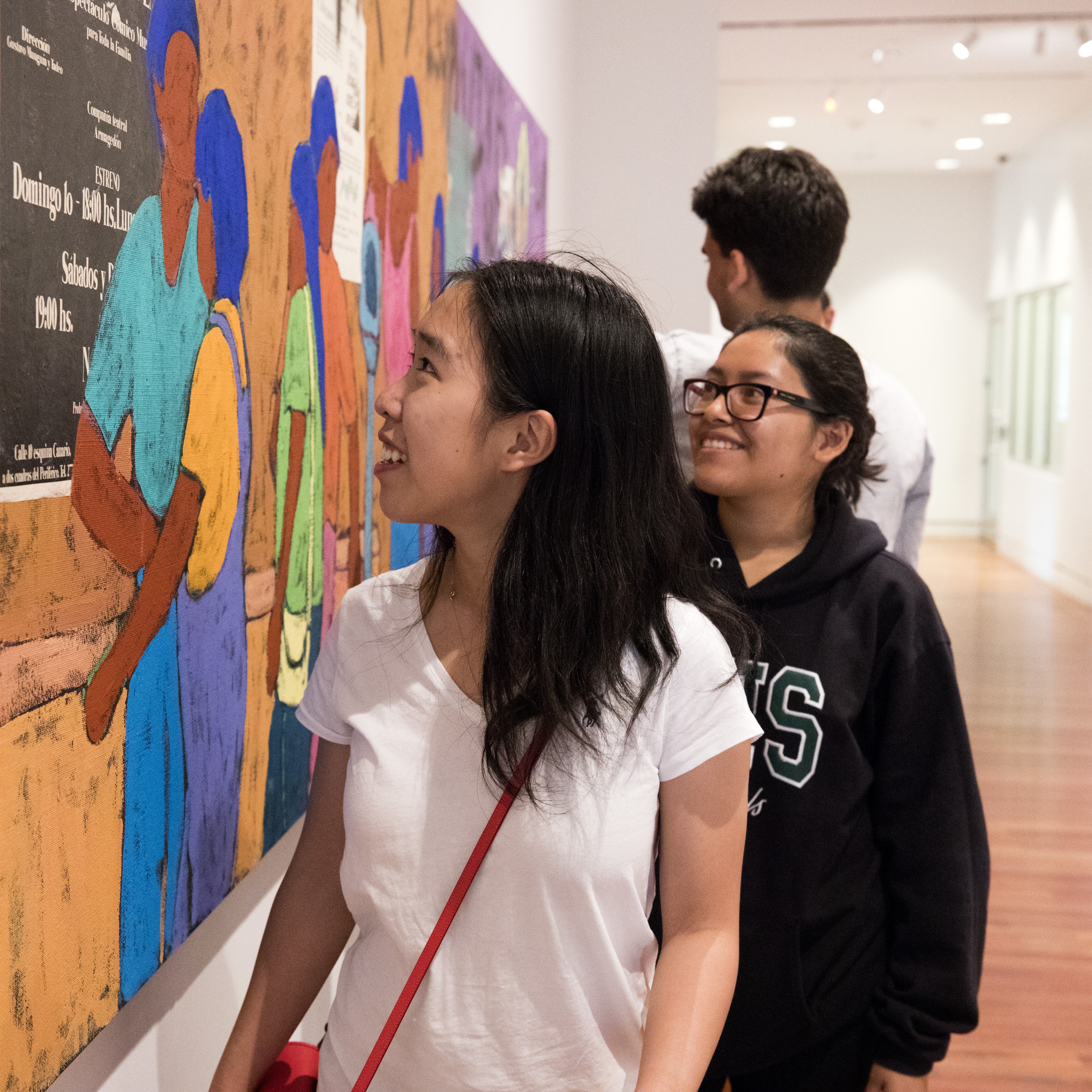 A first gen student looks at a southwestern mural at the Fine Art Center