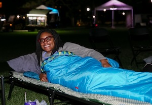 Manya is curled up in a sleeping bag on Tava Quad.