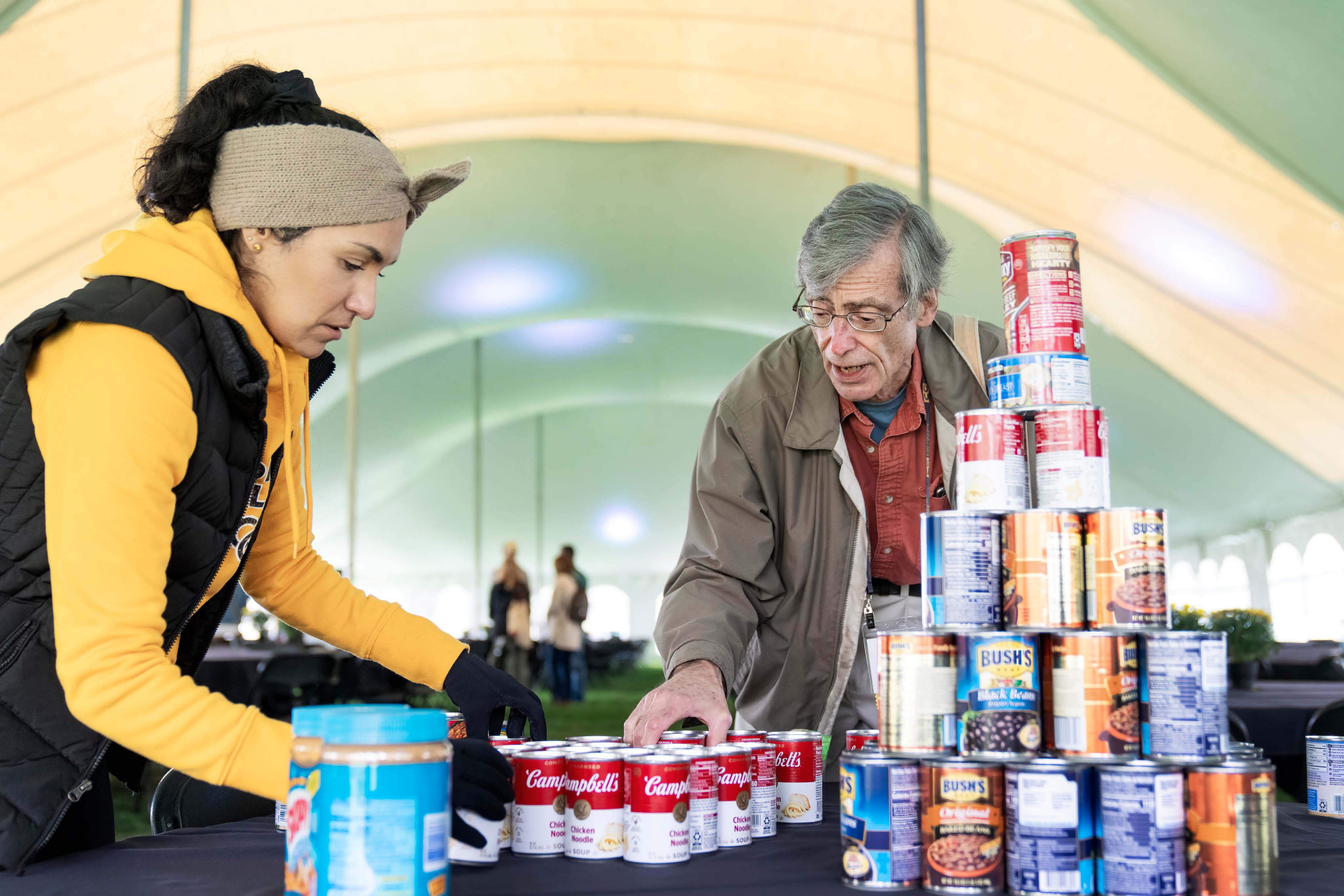 People at a table collecting canned food