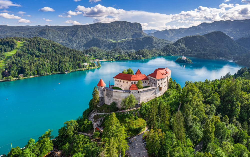 A castle overlooks the placid blue-green waters of Lake Bled in Slovenia